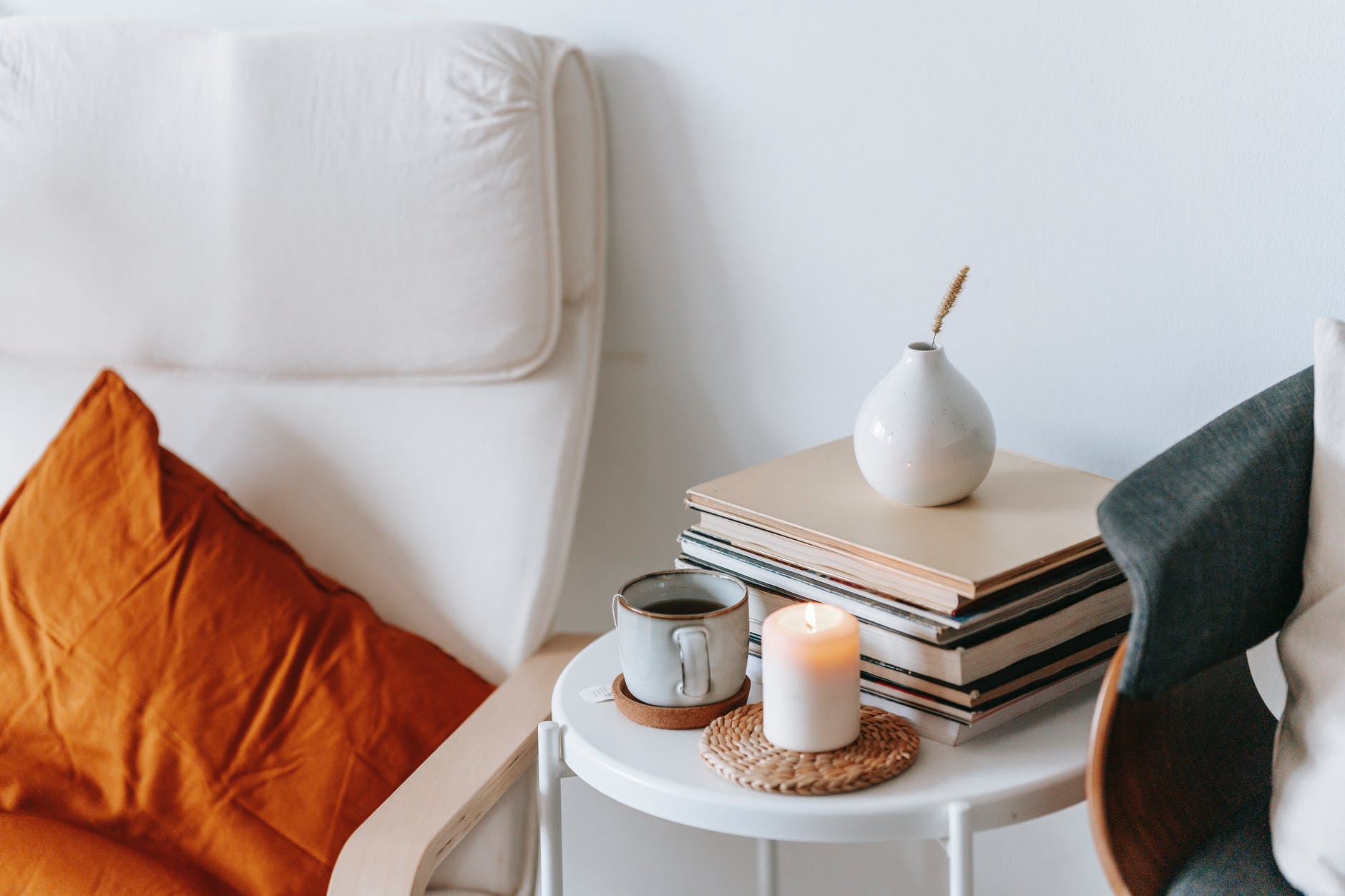 table with tea and burning candle between armchairs in house